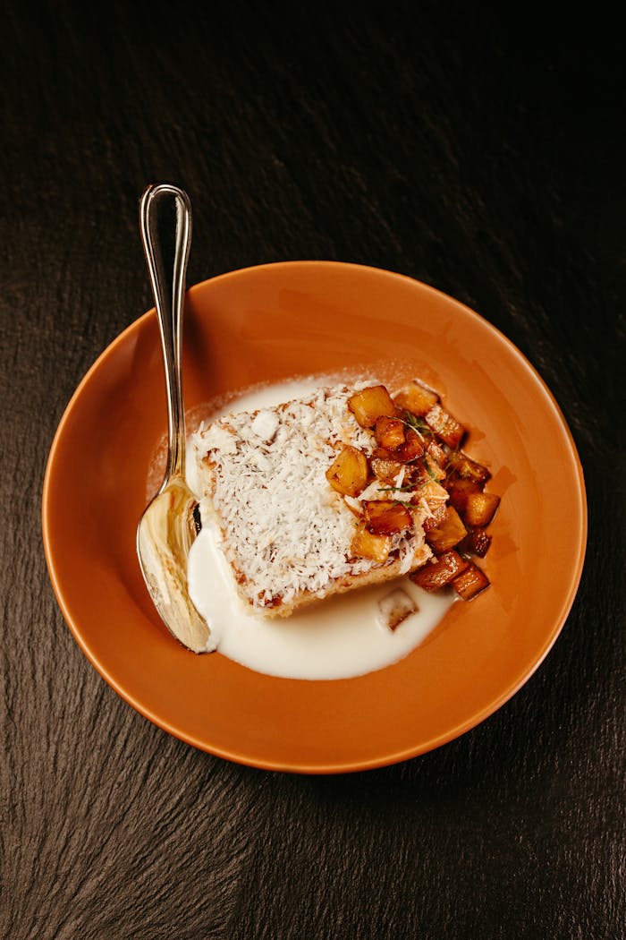 Home A mouthwatering slice of coconut cake with diced pineapple served on a plate.