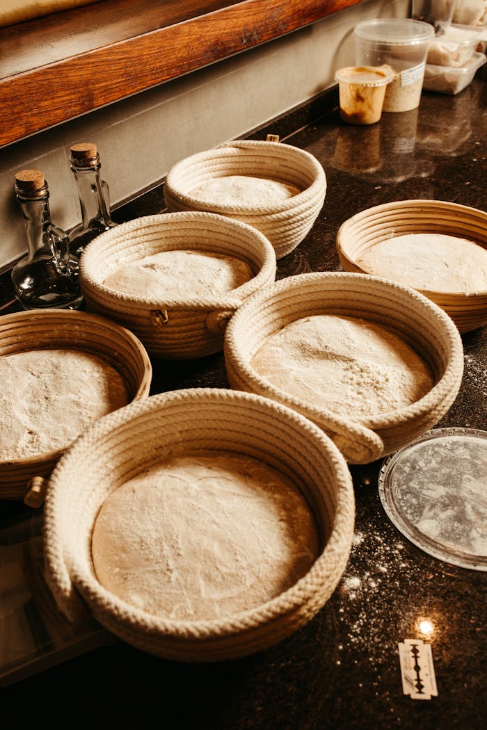 Home Warm rustic kitchen scene with dough rising in woven baskets, ideal for artisanal and homemade baking theme.