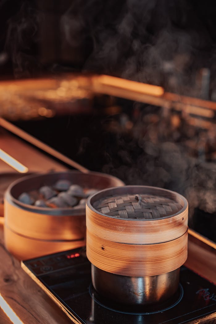 Home Bamboo steamers cooking delicious dumplings on a stovetop, releasing aromatic steam.
